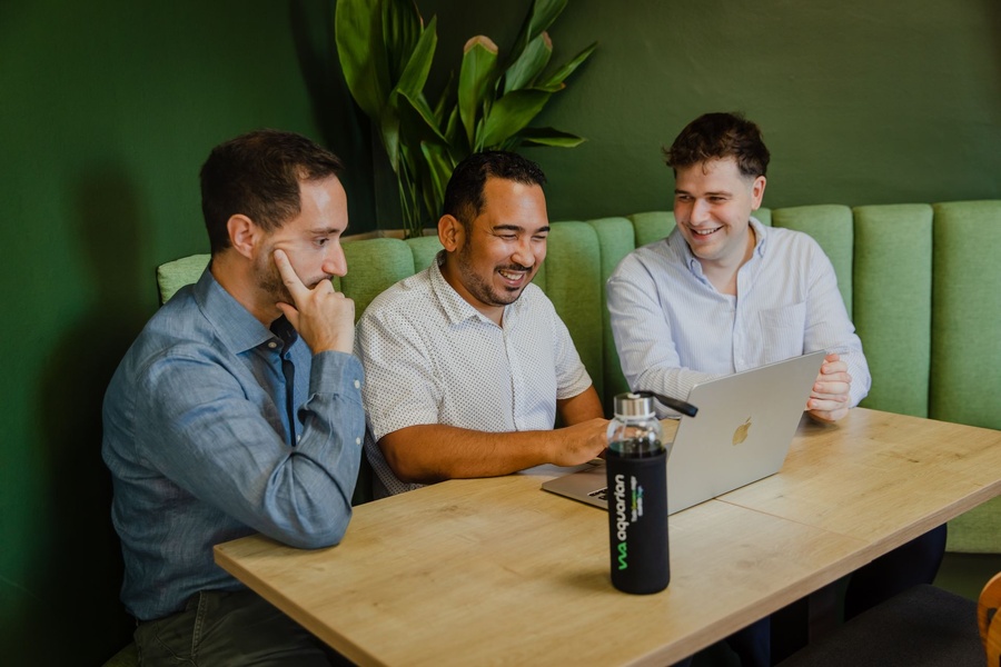 Tres miembros del equipo riendo durante una conversación